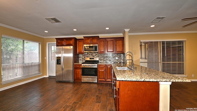 8526 Glen Breeze, San Antonio, TX 78239 - kitchen featuring stainless steel appliances, a sink, a peninsula, dark wood-type flooring, and light stone counters