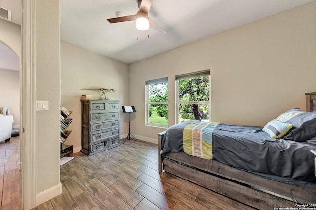 211 Comal Run, Bulverde, TX 78163 - bedroom featuring wood finished floors, baseboards, arched walkways, and ceiling fan