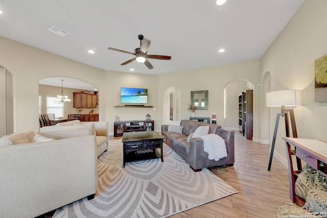 211 Comal Run, Bulverde, TX 78163 - living room with arched walkways, light wood-type flooring, a chandelier, a ceiling fan, and recessed lighting
