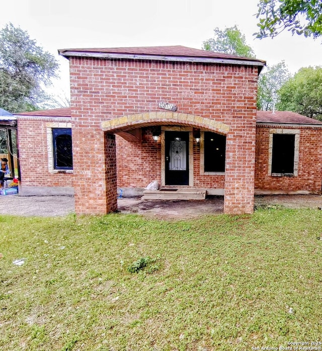 23114 Hickory Shadow, Elmendorf, TX 78112 - view of exterior entry with brick siding and a yard