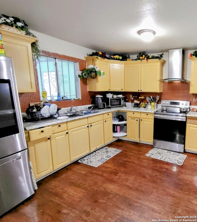 23114 Hickory Shadow, Elmendorf, TX 78112 - kitchen featuring appliances with stainless steel finishes, wall chimney exhaust hood, dark wood finished floors, and tasteful backsplash