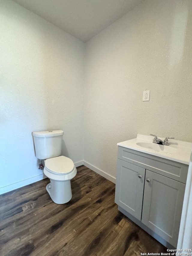 419 W Culberson, Sabinal, TX 78881 - bathroom with vanity, toilet, baseboards, and wood finished floors