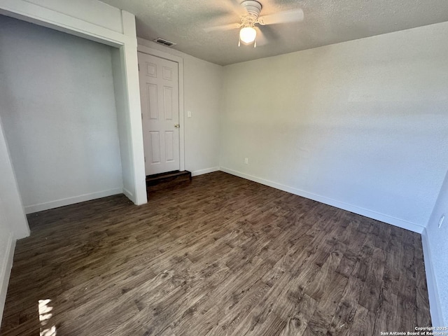 419 W Culberson, Sabinal, TX 78881 - unfurnished bedroom with dark wood-style flooring, baseboards, a textured ceiling, and ceiling fan