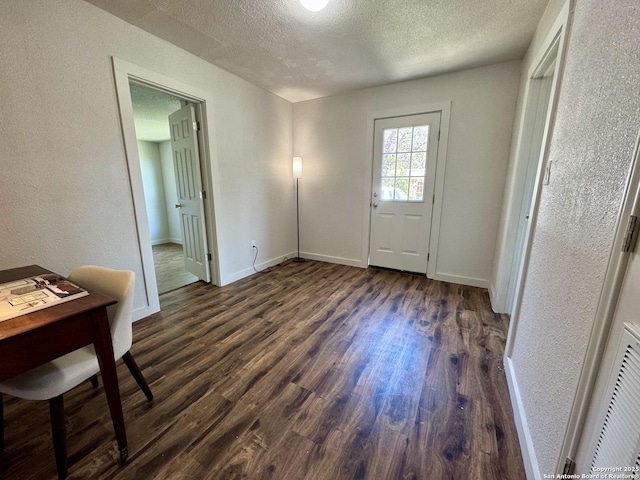 419 W Culberson, Sabinal, TX 78881 - entryway with dark wood finished floors, a textured ceiling, baseboards, and a textured wall