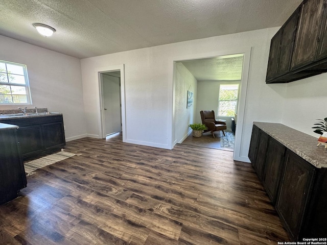 419 W Culberson, Sabinal, TX 78881 - dining space with dark wood-type flooring, a textured ceiling, and baseboards