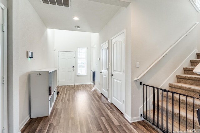 entryway featuring wood finished floors, stairs, baseboards, and recessed lighting