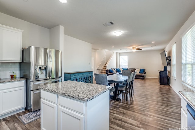 kitchen with stainless steel fridge with ice dispenser, a ceiling fan, open floor plan, dark wood-style flooring, and white cabinets