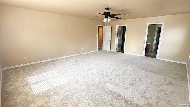 unfurnished bedroom featuring carpet flooring, baseboards, ensuite bath, and a ceiling fan