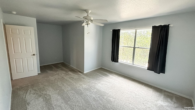 empty room featuring carpet floors, ceiling fan, and baseboards