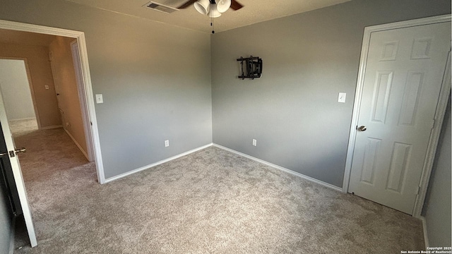carpeted empty room with a ceiling fan and baseboards