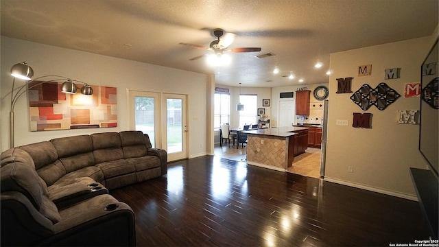living area featuring a ceiling fan, dark wood-style flooring, and baseboards