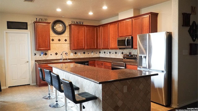 kitchen with appliances with stainless steel finishes, dark countertops, recessed lighting, a sink, and decorative backsplash