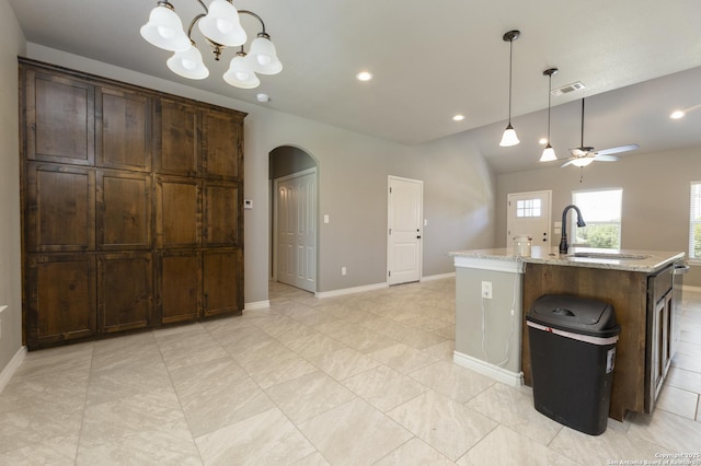 1407 Tanglewood, Spring Branch, TX 78070 - kitchen featuring a sink, arched walkways, a chandelier, ceiling fan, and light stone counters