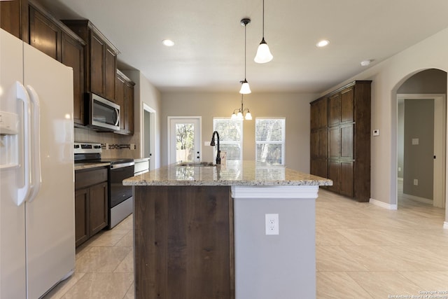 1407 Tanglewood, Spring Branch, TX 78070 - kitchen featuring appliances with stainless steel finishes, a sink, arched walkways, dark brown cabinets, and recessed lighting