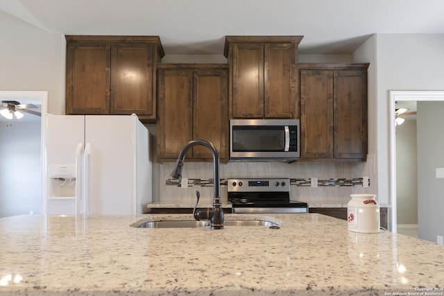 1407 Tanglewood, Spring Branch, TX 78070 - kitchen with stainless steel appliances, a ceiling fan, backsplash, a sink, and dark brown cabinets