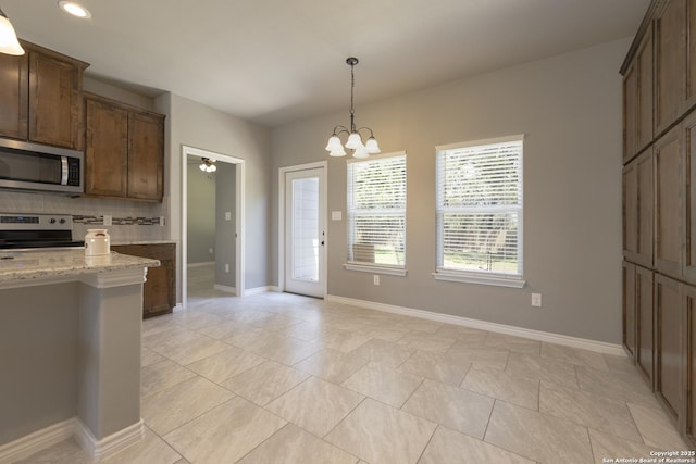 1407 Tanglewood, Spring Branch, TX 78070 - kitchen featuring stainless steel appliances, a chandelier, decorative backsplash, pendant lighting, and light stone countertops