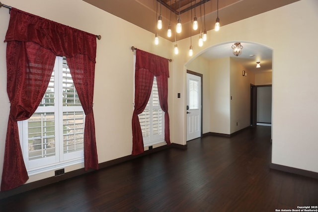 1181 County Road 4516, Castroville, TX 78009 - empty room with arched walkways, baseboards, and wood finished floors