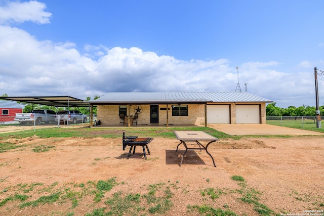 2050 Adj Ln, Fredericksburg, TX 78624 - view of front of property featuring fence, brick siding, dirt driveway, an attached garage, and a carport
