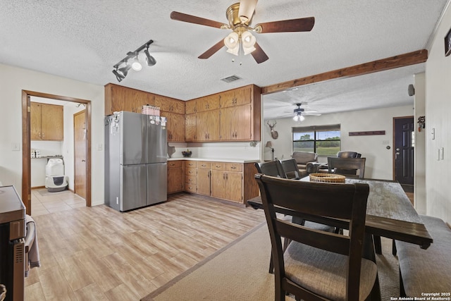 2050 Adj Ln, Fredericksburg, TX 78624 - kitchen featuring freestanding refrigerator, a ceiling fan, a textured ceiling, brown cabinets, and light countertops