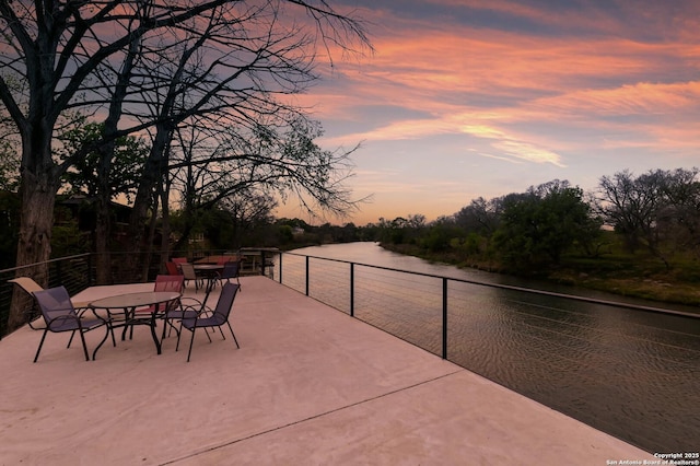 315 E Klein, New Braunfels, TX 78130 - patio terrace at dusk featuring a water view and outdoor dining area