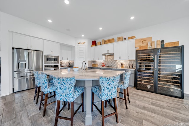 11109 Molly Run, San Antonio, TX 78254 - kitchen featuring appliances with stainless steel finishes, a kitchen breakfast bar, a sink, white cabinetry, and recessed lighting