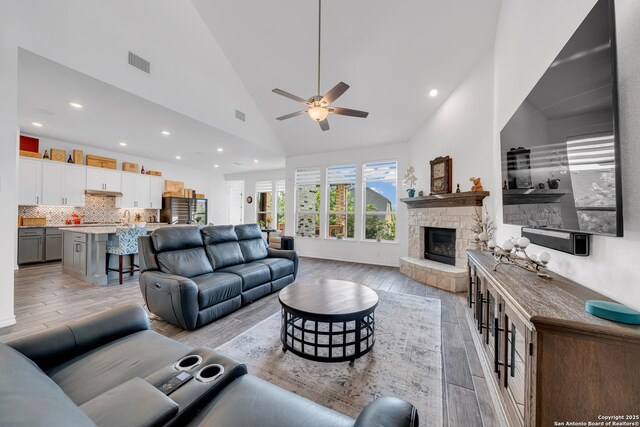 11109 Molly Run, San Antonio, TX 78254 - living area featuring a ceiling fan, light wood-style floors, recessed lighting, a stone fireplace, and high vaulted ceiling