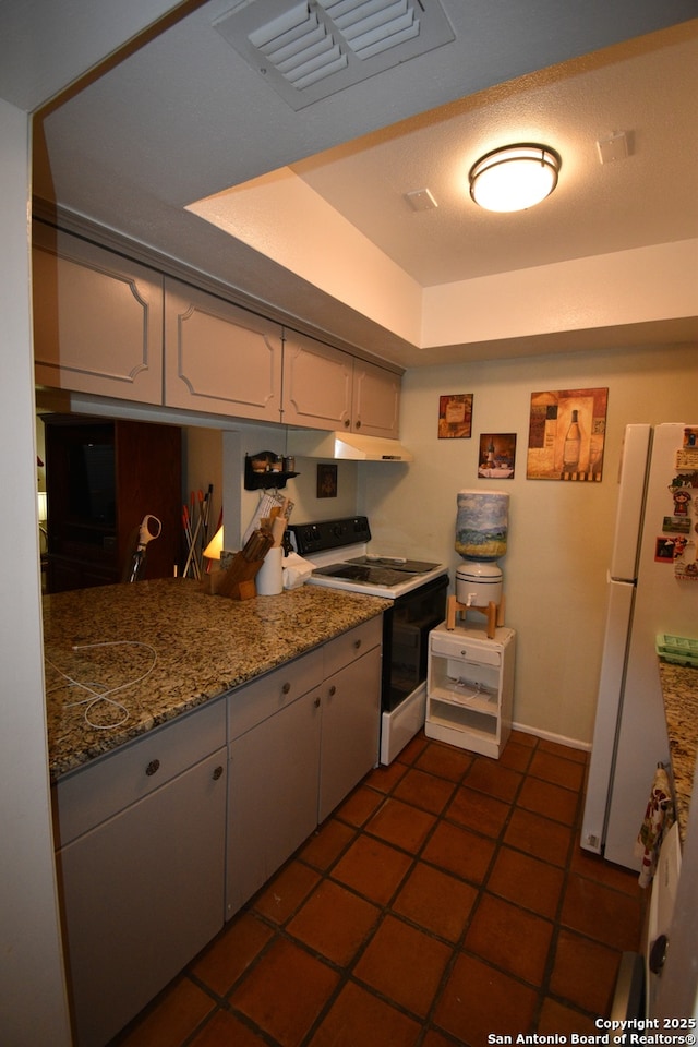 8401 New Braunfels Unit 125, San Antonio, TX 78209 - kitchen featuring range with electric stovetop, freestanding refrigerator, under cabinet range hood, white cabinets, and dark tile patterned floors