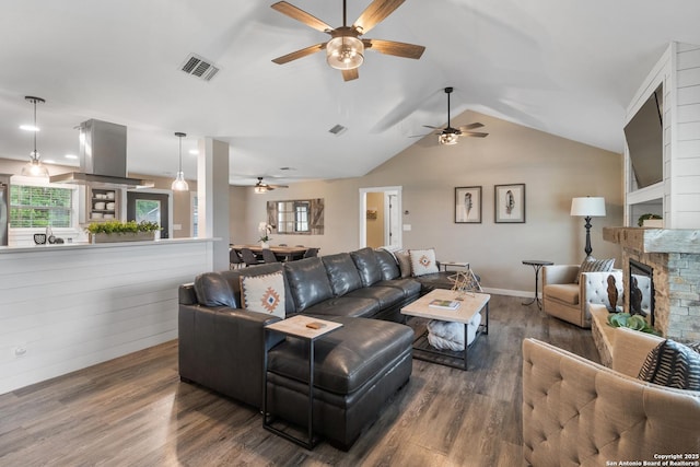 296 Cherokee Dr, Bandera, TX 78003 - living area with a ceiling fan, wood finished floors, vaulted ceiling, a fireplace, and plenty of natural light