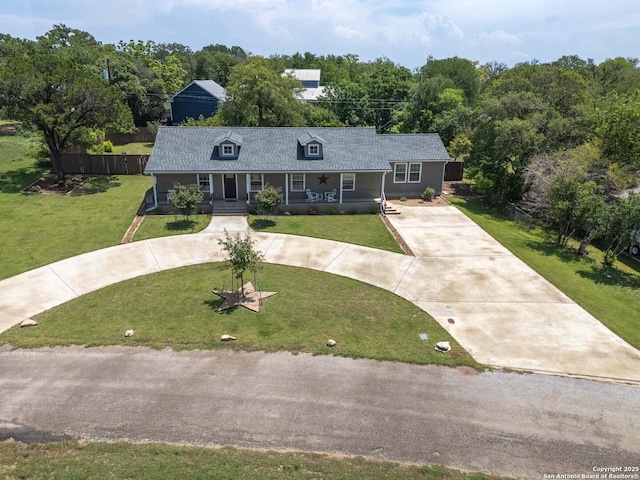 296 Cherokee Dr, Bandera, TX 78003 - view of front of house with covered porch, curved driveway, a front yard, and roof with shingles