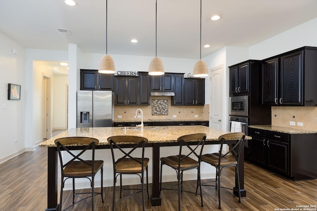 1041 Water Oak, Schertz, TX 78154 - kitchen featuring appliances with stainless steel finishes, a sink, dark wood finished floors, a breakfast bar area, and tasteful backsplash