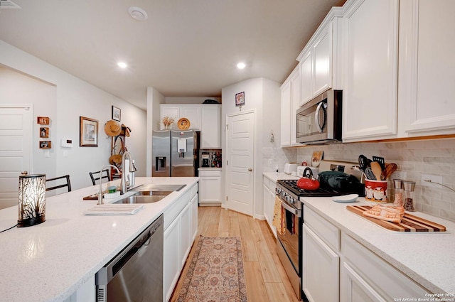 10227 Azealia Way, Boerne, TX 78006 - kitchen featuring appliances with stainless steel finishes, a sink, light wood finished floors, backsplash, and recessed lighting