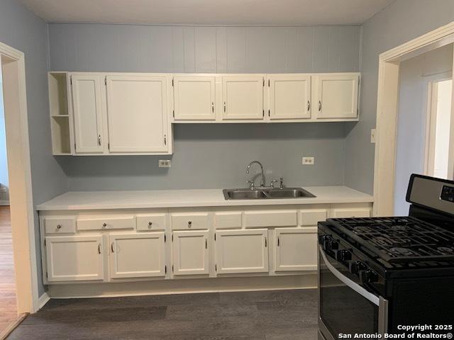 434 Hermine, San Antonio, TX 78212 - kitchen with stainless steel range with gas stovetop, a sink, white cabinetry, light countertops, and dark wood-style flooring