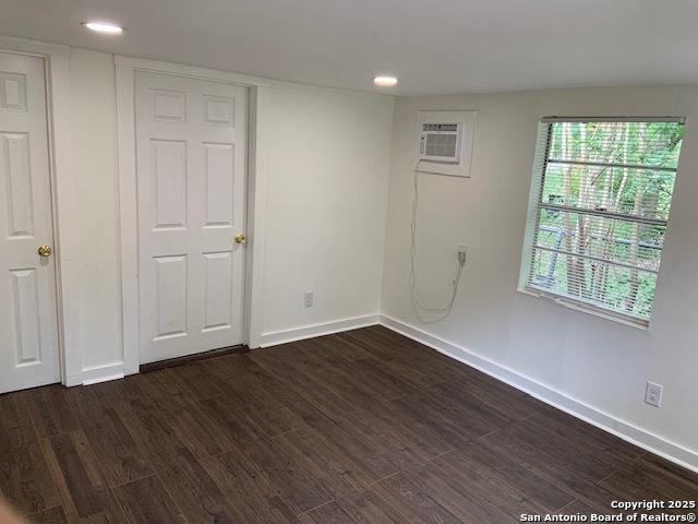 434 Hermine, San Antonio, TX 78212 - unfurnished bedroom with dark wood-style floors, baseboards, multiple windows, a wall mounted air conditioner, and recessed lighting
