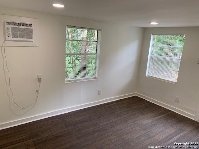 434 Hermine, San Antonio, TX 78212 - empty room featuring dark wood-style flooring, plenty of natural light, baseboards, a wall mounted air conditioner, and recessed lighting
