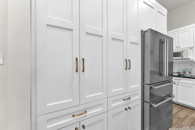 740 Sharp Spgs, Bulverde, TX 78163 - kitchen featuring high end refrigerator, white microwave, white cabinetry, light wood-type flooring, and tasteful backsplash