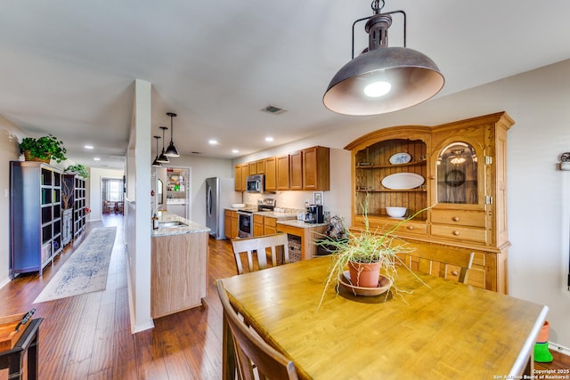 dining area with dark wood finished floors, recessed lighting, and baseboards