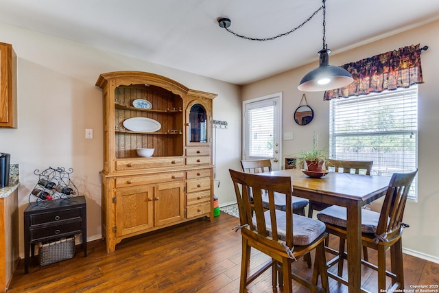dining space featuring dark wood finished floors and baseboards