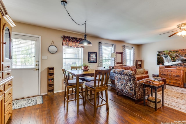 dining room featuring dark wood-style floors, a ceiling fan, and baseboards