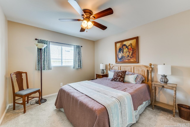 bedroom featuring light carpet, a ceiling fan, and baseboards