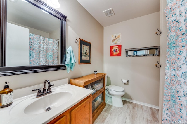 bathroom with toilet, vanity, baseboards, and curtained shower