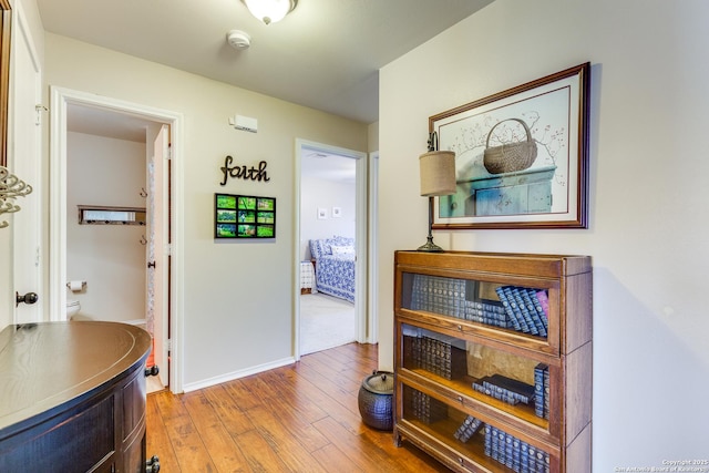 corridor featuring hardwood / wood-style flooring and baseboards