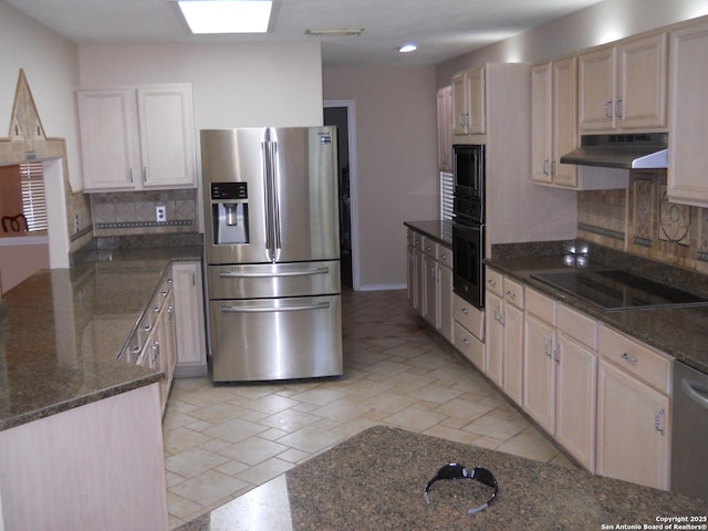 kitchen featuring black appliances, under cabinet range hood, tasteful backsplash, dark stone countertops, and a peninsula
