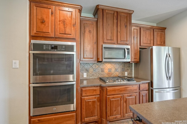 kitchen with stainless steel appliances, decorative backsplash, and brown cabinets