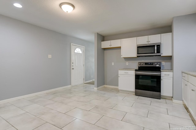 4342 Lehman Dr, Kirby, TX 78219 - kitchen featuring appliances with stainless steel finishes, white cabinets, light tile patterned floors, and baseboards