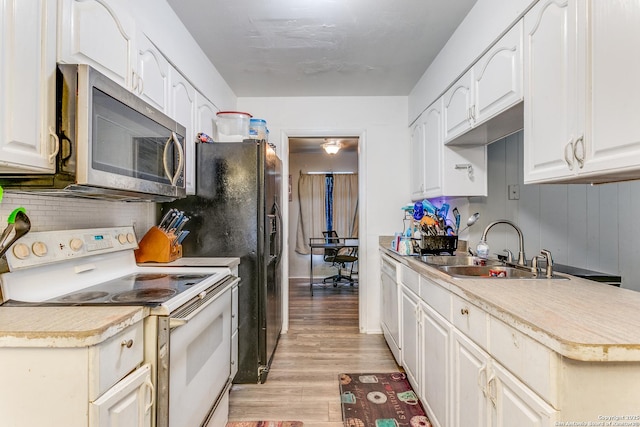 5118 Crusade Dr, San Antonio, TX 78218 - kitchen with white range with electric stovetop, stainless steel microwave, a sink, light wood-type flooring, and backsplash