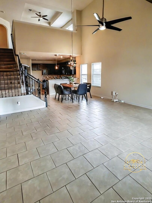 6635 Cibola Frst, San Antonio, TX 78233 - dining area featuring a ceiling fan, healthy amount of natural light, a towering ceiling, stairs, and baseboards