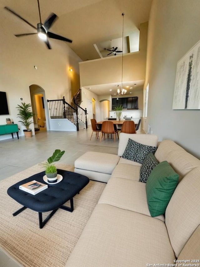 6635 Cibola Frst, San Antonio, TX 78233 - living area featuring ceiling fan, arched walkways, high vaulted ceiling, stairway, and a chandelier