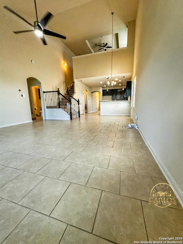 6635 Cibola Frst, San Antonio, TX 78233 - unfurnished living room featuring a ceiling fan, arched walkways, high vaulted ceiling, stairs, and baseboards