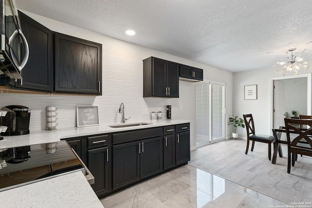 3115 Bluefield, San Antonio, TX 78230 - kitchen featuring a sink, a chandelier, light countertops, a textured ceiling, and baseboards