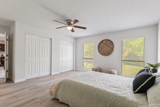3115 Bluefield, San Antonio, TX 78230 - bedroom with two closets, wood finished floors, baseboards, and ceiling fan